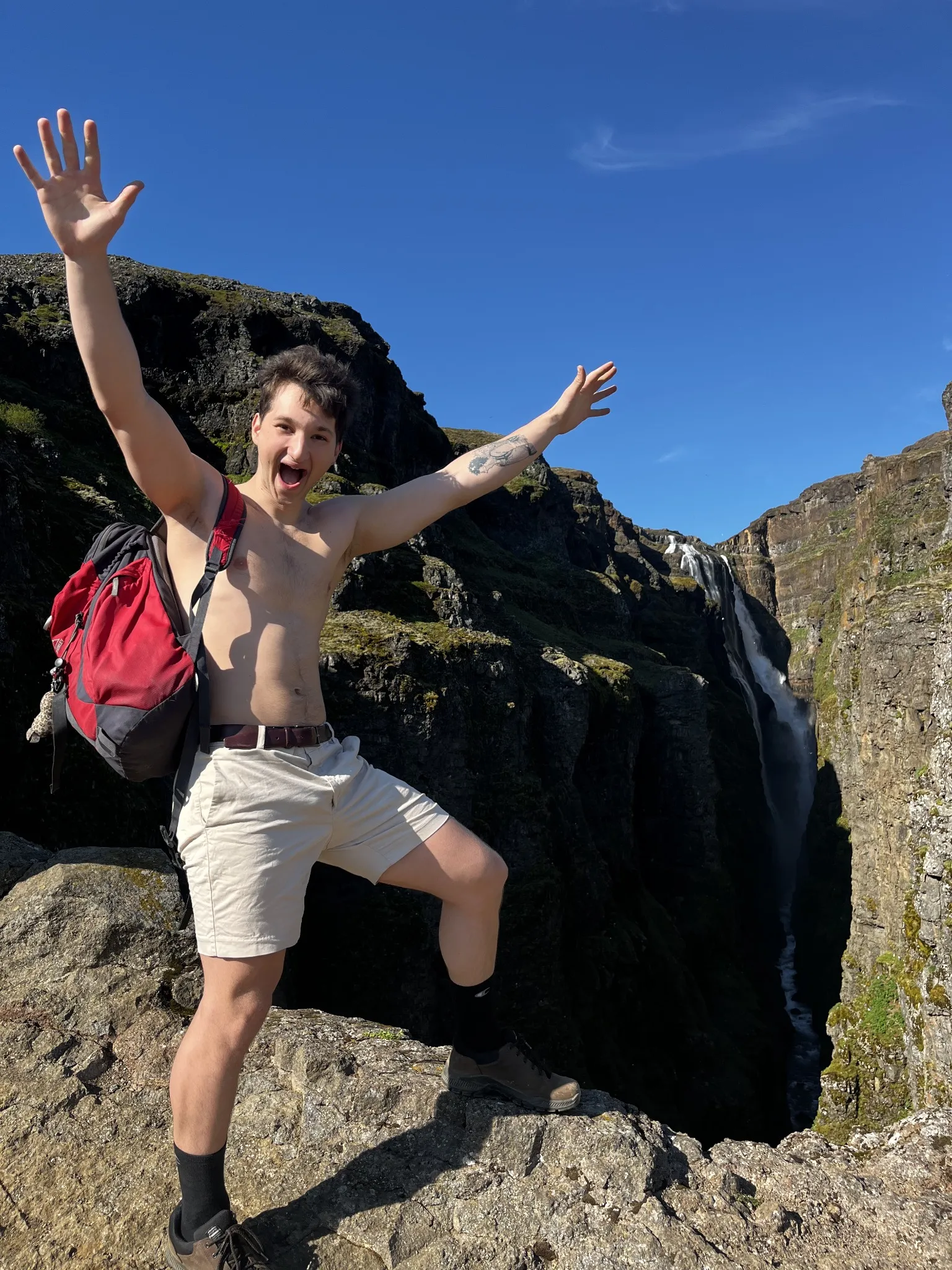 A traveller jumping between dark rocks beneath a blue sky